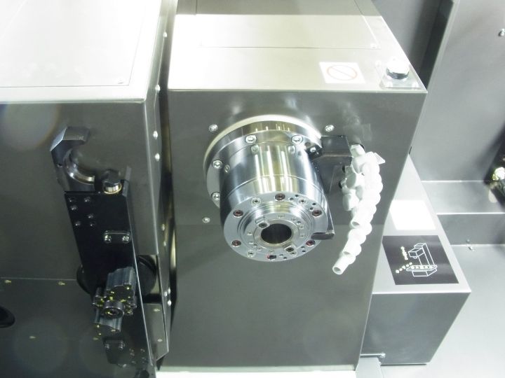 CNC machine spindle with an empty tool holder and coolant nozzles.