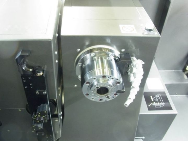CNC machine spindle with an empty tool holder and coolant nozzles.