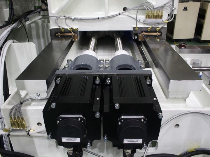 CNC machine dual servo motors with ball screw drives and linear rails.