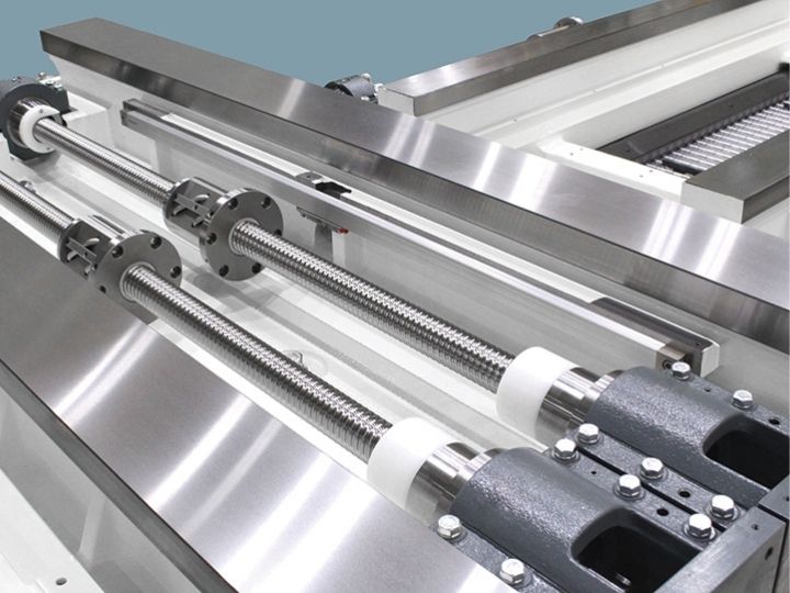 CNC machine dual ball screw drives with linear guides and support bearings.