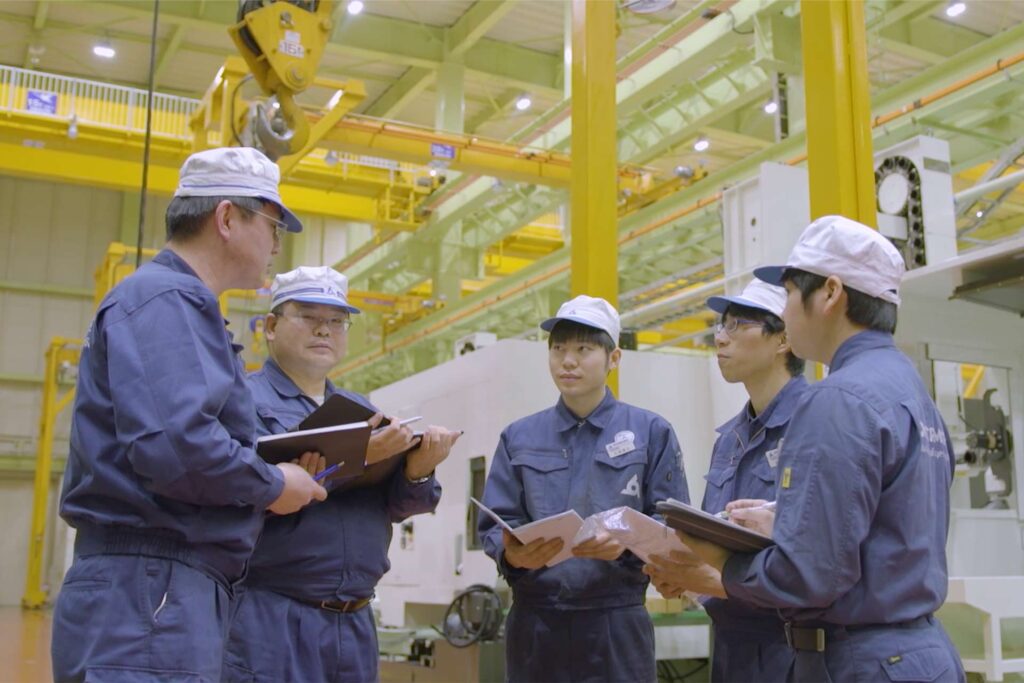 A group of four factory workers talking.