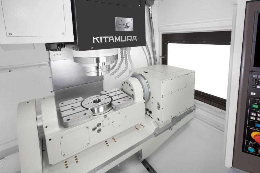 Interior of a Kitamura 5-axis machining center featuring a tilting rotary table and spindle head, designed for complex multi-angle part machining.