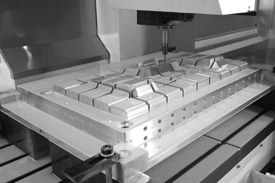 Bridge-style machining center performing high-precision milling on a large aluminum workpiece, ideal for mold or die manufacturing.