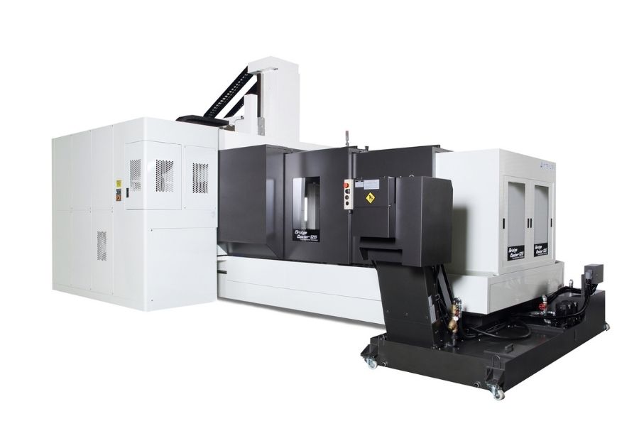 Exterior view of a large-scale Kitamura Bridgecenter CNC machine, featuring an enclosed gantry structure and integrated chip conveyor system.