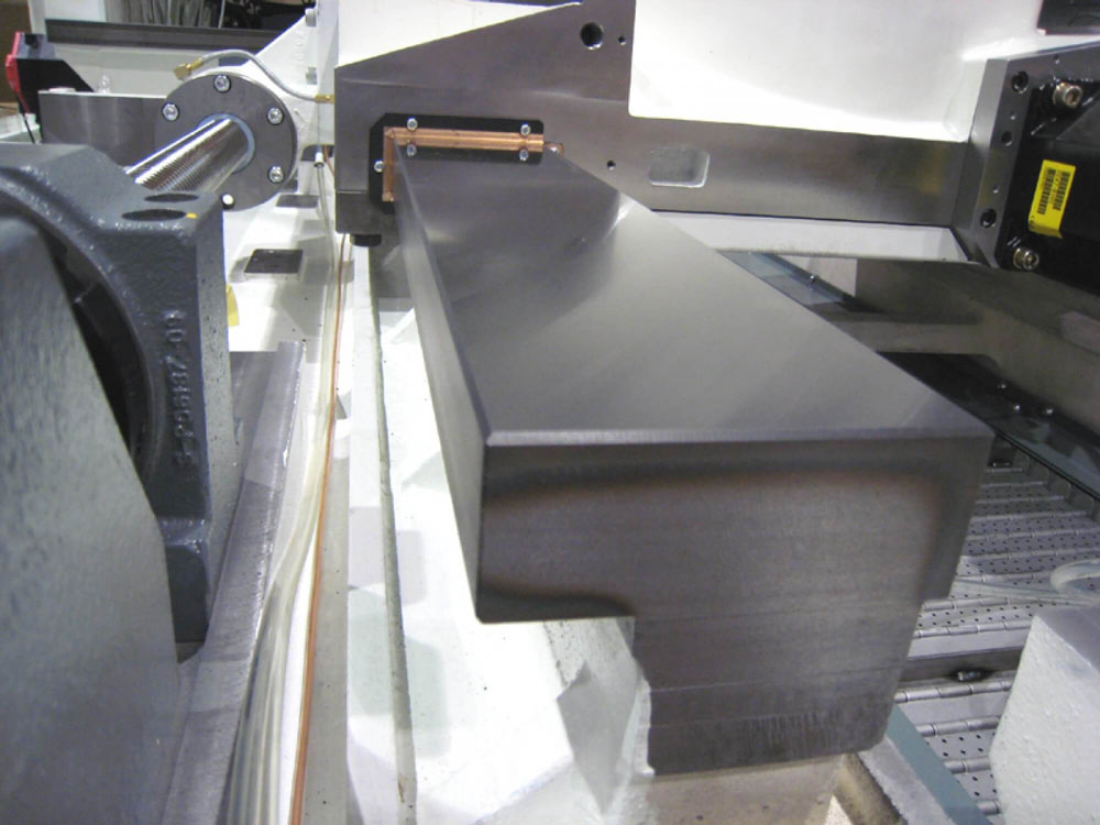 A close-up view of a precision-machined metal surface on industrial equipment, showcasing a smooth, reflective guideway.
